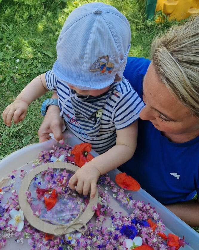 Untitled Dziecko wykonujące pracę plastyczną z kwiatów w ogrodzie Żłobka Mariposa