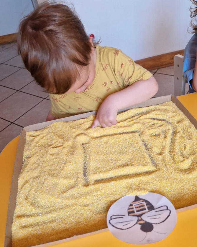 Untitled Dziecko maluje palcem po kaszy w żłobku Mariposa